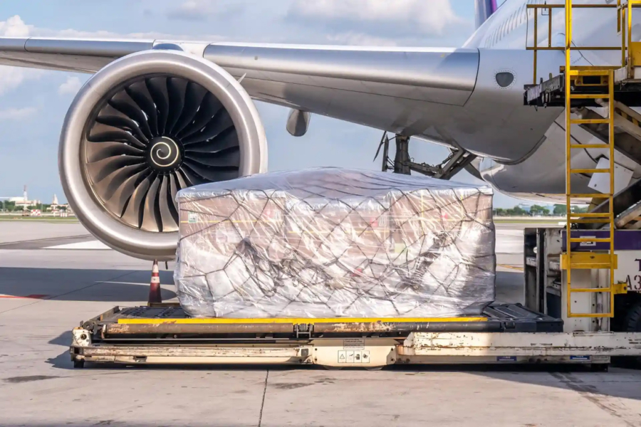 Une opération de manutention de fret aérien sur le tarmac d'un aéroport.
