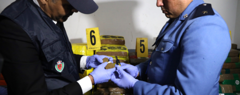Un élément de la Sûreté nationale et un agent des douanes examinant la cargaison de chira saisie au port Tanger Med, le 19 mars 2026.