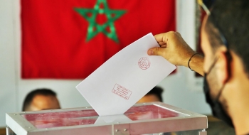 Un électeur plaçant son bulletin de vote dans une urne lors des élections de 2021.