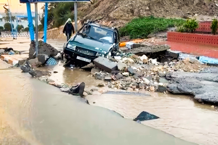 Une voiture bloquée dans les débris d'une chaussée endommagée par les inondations survenues à Safi, le 14 décembre 2025