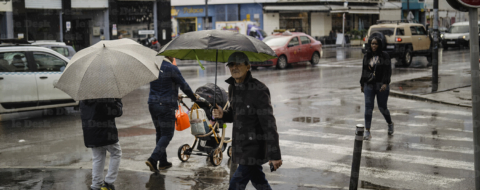 Des passant dans une artère de Casablanca sous la pluie.