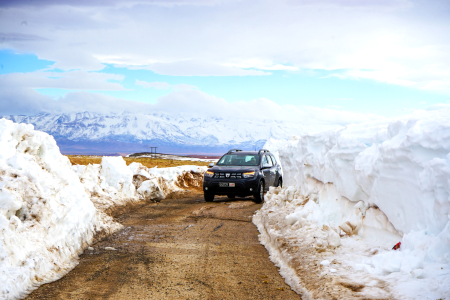 Un véhicule des autorités locales sur une route de montagne enneigée dans la province de Midelt.