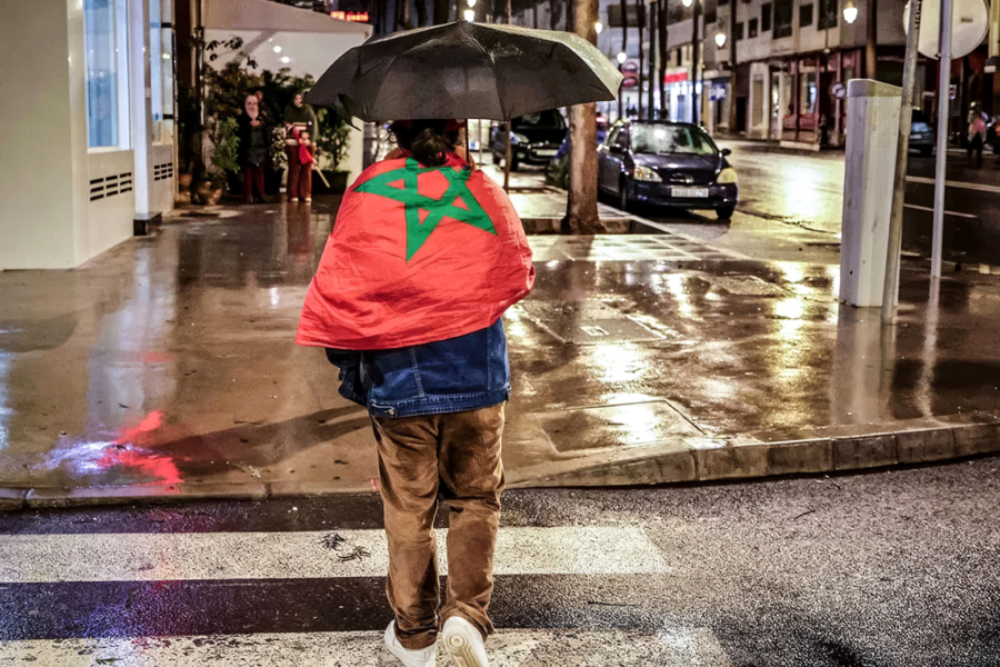 Une jeune fille sous la pluie dans une rue de Rabat.