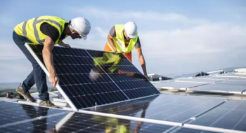Des techniciens installant des panneaux solaires en toiture.