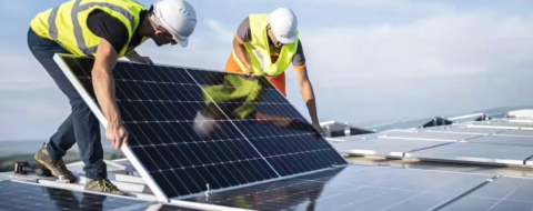 Des techniciens installant des panneaux solaires en toiture.