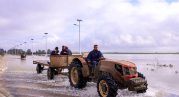 Un agriculteur circulant au volant de son tracteur sur une route inondée dans la commune d’El Houafate, relevant de la province de Sidi Kacem.