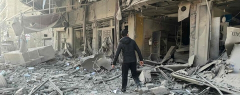 Un homme se fraye un chemin à travers les décombres après les frappes aériennes israéliennes nocturnes dans la banlieue sud de Beyrouth