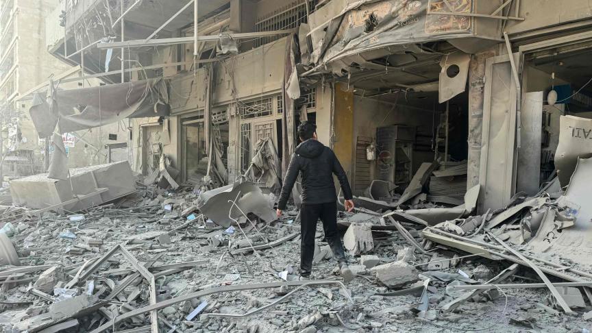 Un homme se fraye un chemin à travers les décombres après les frappes aériennes israéliennes nocturnes dans la banlieue sud de Beyrouth