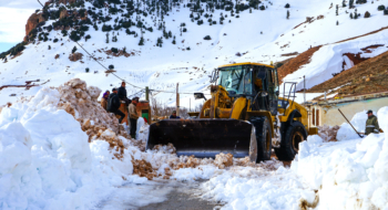 Une pelleteuse dégageant une route de montagne dans la province de Midelt. Crédit : MAP