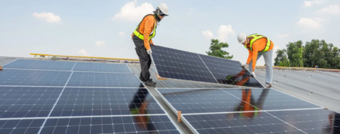 Des techniciens installant des panneaux solaires en toiture.