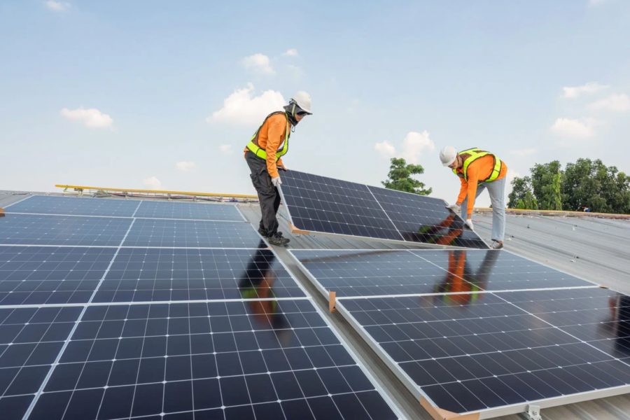 Des techniciens installant des panneaux solaires en toiture.
