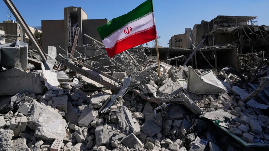 Un drapeau iranien planté parmi les décombres d’un poste de police détruit à Téhéran lors de la campagne militaire américano-israélienne. (AP Photo/Vahid Salemi)