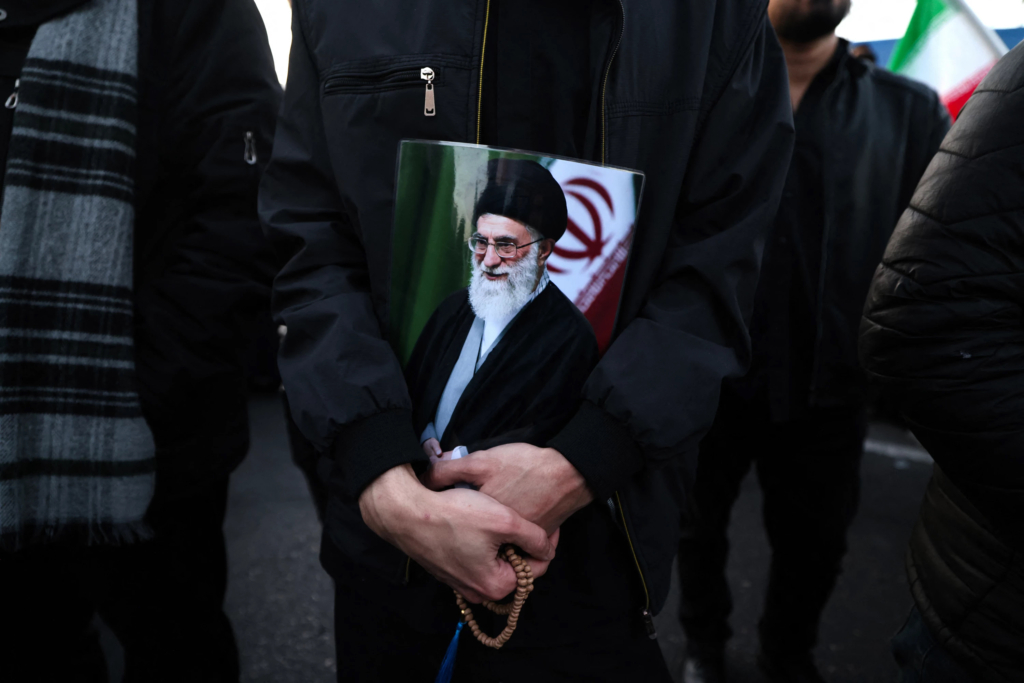 Un homme tient une affiche du guide suprême iranien, l’ayatollah Ali Khamenei, tué lors de frappes conjointes américaines et israéliennes, alors qu’il rejoint d’autres personnes en deuil sur une place à Téhéran, le 1er mars 2026. Crédit : AFP