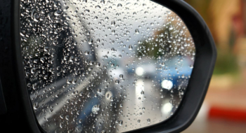 Une artère de Casablanca sous pluie, reflétée dans un rétroviseur.