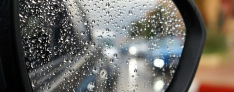 Une artère de Casablanca sous pluie, reflétée dans un rétroviseur.