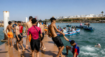 Des jeunes se baignent depuis une plate-forme de la plage de Salé, près de Rabat, pendant une vague de chaleur au Maroc, le 29 juin 2025