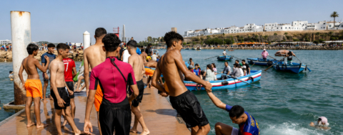 Des jeunes se baignent depuis une plate-forme de la plage de Salé, près de Rabat, pendant une vague de chaleur au Maroc, le 29 juin 2025